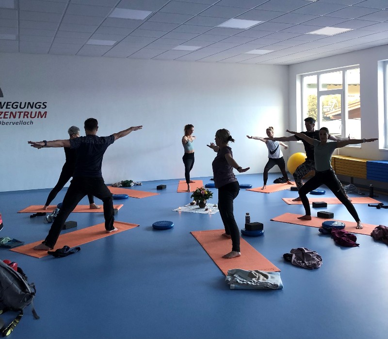 Mitarbeitende bei Yoga-Übungen im Gymnastikraum