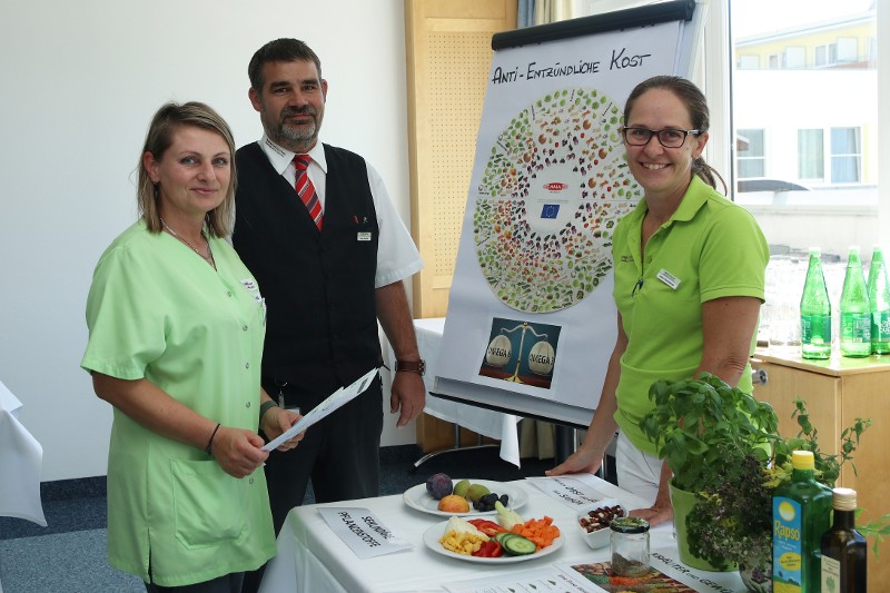 zwei Mitarbeiterinnen und ein Mitarbeiter informieren zu Anti-entzündlicher Ernährung
