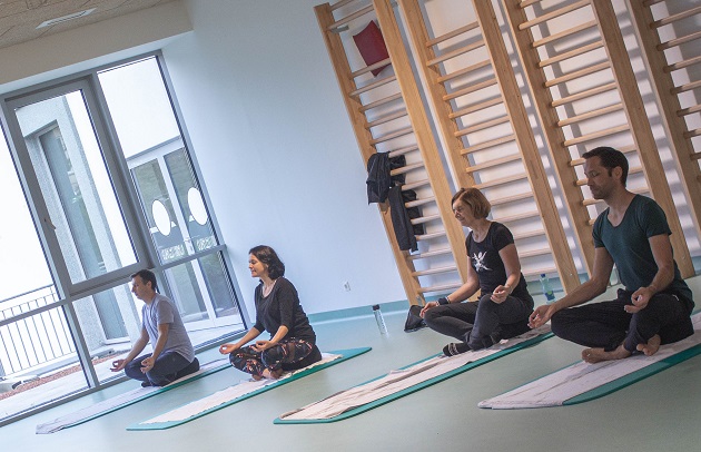 4 Mitarbeitende beim Meditieren auf Yoga-Matten.