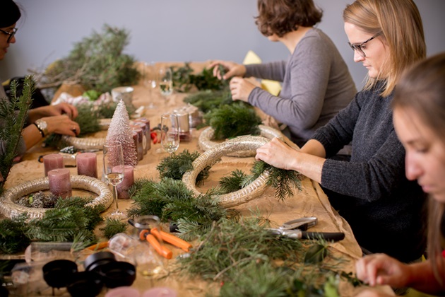 Mitarbeitende beim Adventskranzbinden.